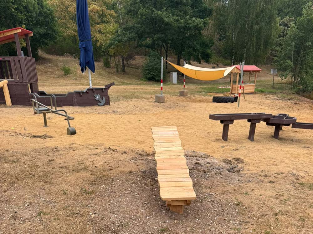 Ein Spielplatz mit Balancieranlage und weiteren Spielgeräten.
