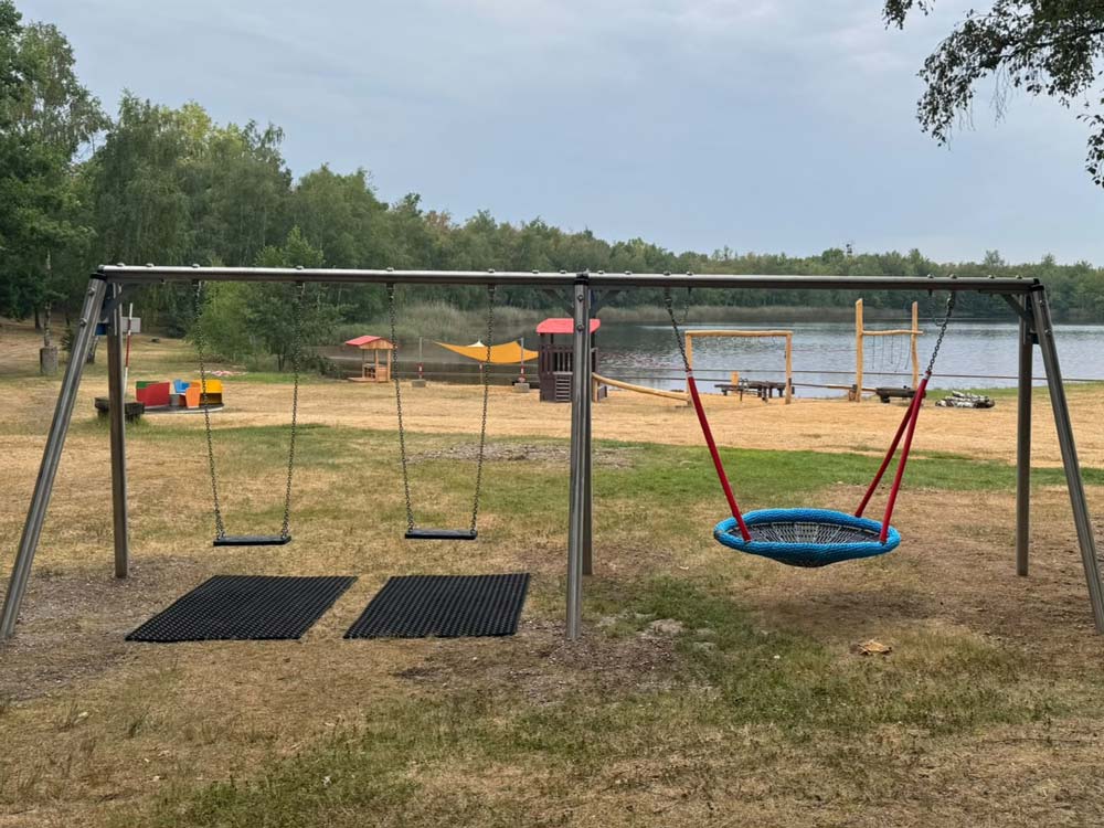 Ein Spielplatz mit Schaukeln und weiteren Spielgeräten am Zwieselsmaarsee.